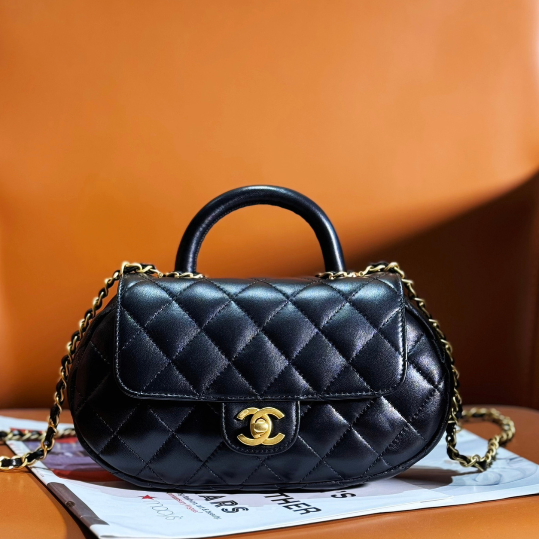 Chan*l 24c top handle flap bag in black lambskin - main image